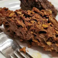 Fetta di torta con strati di pasta e noci, ricoperta di cacao. Un dolce invitante, perfetto per chi ama i maccheroni dolci con le noci.