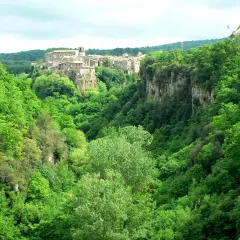 Un borgo medievale arroccato su una rupe domina le verdi gole del Biedano, immerse in una lussureggiante vegetazione.