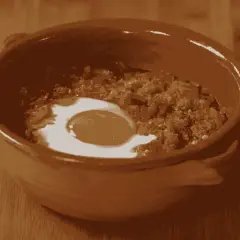 Un uovo in camicia su un letto di pane raffermo e verdure, pronto per la **acquacotta ricetta**. Un piatto rustico e saporito.