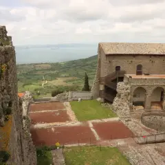 Rocche antiche e un lago sullo sfondo, un paesaggio che evoca la storia della Tuscia, dove si trova questo luogo.
