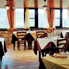 Interno di un'antica cantina a Caprarola, con tavoli apparecchiati e vista panoramica.