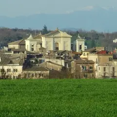 Paesaggio di Gallese, borgo vicino Viterbo, con case e una chiesa imponente, sullo sfondo montagne.