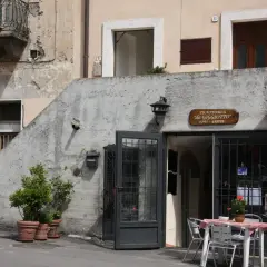 Trattoria "da Giggiotto" a Ischia di Castro, Viterbo. Tavolini all'aperto invitano a gustare i sapori locali.