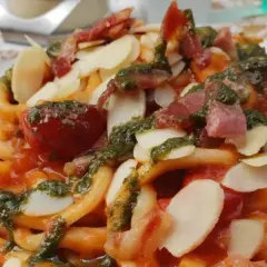 Pasta con pomodoro, pesto, mandorle e pancetta croccante, un piatto da gustare all'enoteca Civita.