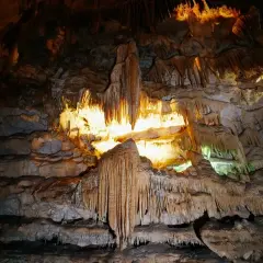Interno di una grotta con stalattiti e stalagmiti illuminate, un paesaggio sotterraneo mozzafiato nelle grotte di Civita Castellana.