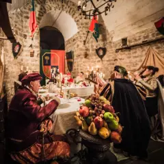 Banchetto medievale a Soriano nel Cimino, con figuranti in costume e un ricco centrotavola di frutta.