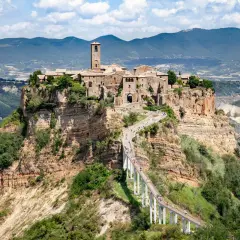 Civita di Bagnoregio, un borgo medievale arroccato su una rupe, raggiungibile tramite un lungo ponte pedonale. La provincia di Viterbo custodisce questo gioiello.
