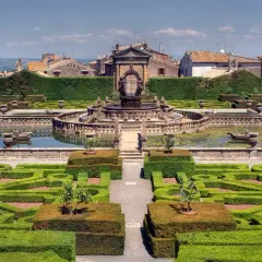 Giardini all'italiana con fontana centrale e siepi geometriche. Si vede il borgo di Bagnaia sullo sfondo.
