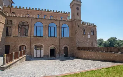 Il **Palazzo Doebbing**, con la sua torre dell'orologio e le ampie finestre ad arco, si affaccia su un cortile lastricato sotto un cielo azzurro.