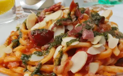 Pasta con pomodoro, pesto, mandorle e pancetta croccante, un piatto da gustare all'enoteca Civita.