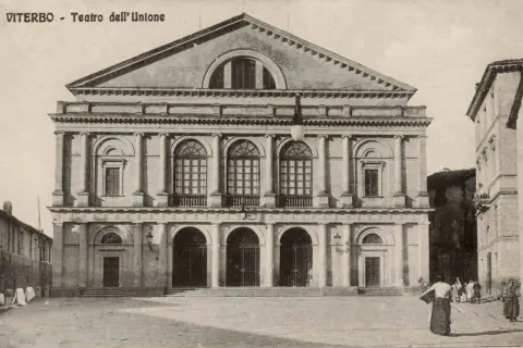 Il maestoso **Teatro dell'Unione** di Viterbo, con la sua facciata neoclassica e le arcate imponenti, si erge in una piazza storica.