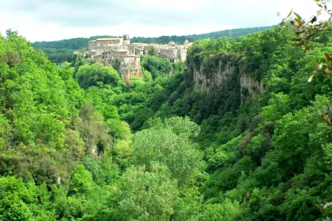 Un borgo medievale arroccato su una rupe domina le verdi gole del Biedano, immerse in una lussureggiante vegetazione.