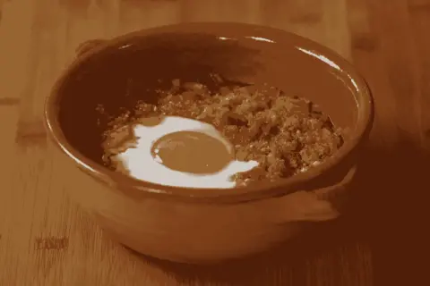 Un uovo in camicia su un letto di pane raffermo e verdure, pronto per la **acquacotta ricetta**. Un piatto rustico e saporito.