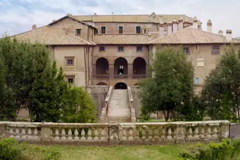 Villa Giustiniani Bassano Romano: imponente residenza storica circondata da verde, con scalinata e loggiato ad archi.