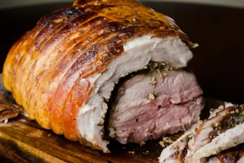Porchetta viterbese succulenta, con crosta dorata e carne rosata, pronta per essere gustata.