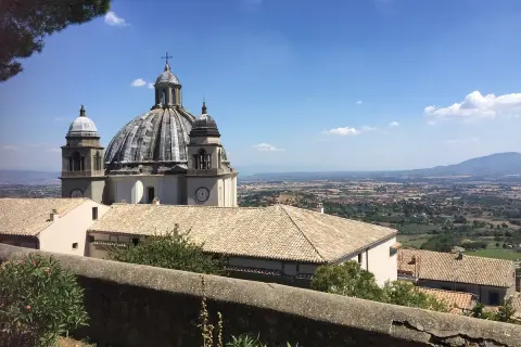 La Rocca dei Papi domina un paesaggio collinare sotto un cielo azzurro.