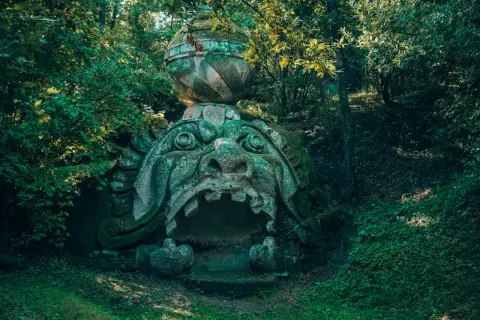 Ingresso del museo dei mostri: una bocca di pietra spalancata, incastonata nel verde di un bosco incantato.