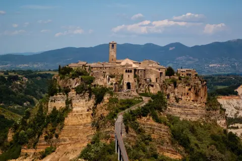 Civita di Bagnoregio, un borgo arroccato su speroni di tufo, domina i calanchi circostanti. Un ponte collega il paese alla terraferma.