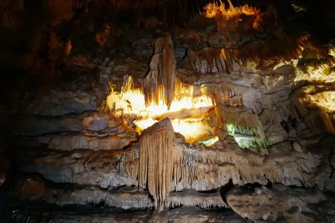 Interno di una grotta con stalattiti e stalagmiti illuminate, un paesaggio sotterraneo mozzafiato nelle grotte di Civita Castellana.