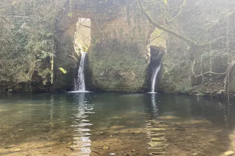 Cascate naturali a Barbarano Romano, con acqua cristallina che scende da antiche rovine ricoperte di muschio.