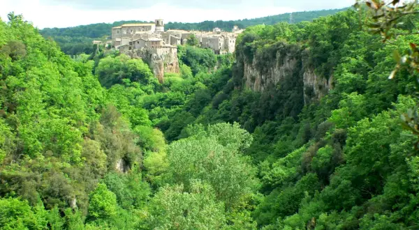 Un borgo medievale arroccato su una rupe domina le verdi gole del Biedano, immerse in una lussureggiante vegetazione.