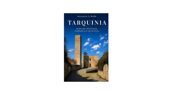 Copertina libro "Tarquinia: Guida alla città etrusca, medievale e al suo territorio". Torre medievale e chiesa sotto un cielo azzurro.