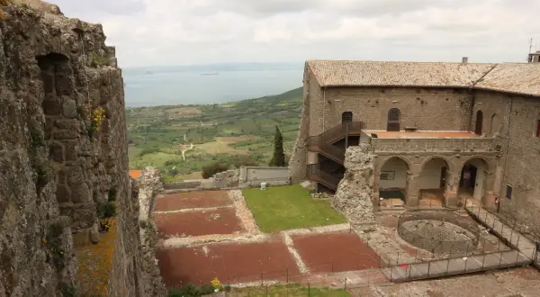 Rocche antiche e un lago sullo sfondo, un paesaggio che evoca la storia della Tuscia, dove si trova questo luogo.