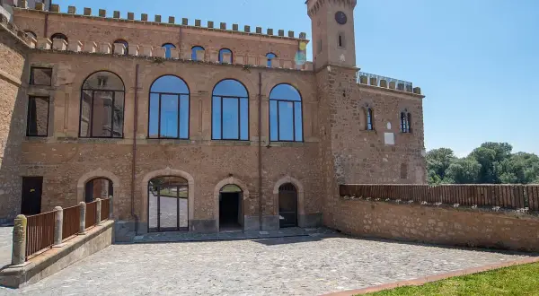Il **Palazzo Doebbing**, con la sua torre dell'orologio e le ampie finestre ad arco, si affaccia su un cortile lastricato sotto un cielo azzurro.