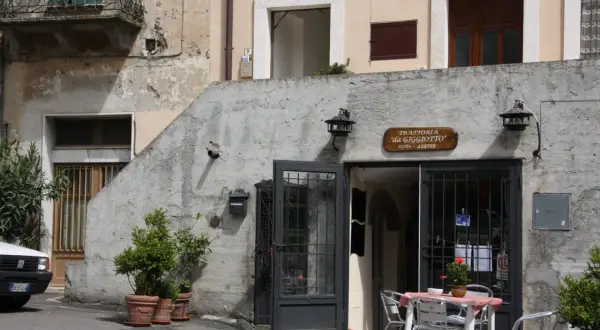 Trattoria "da Giggiotto" a Ischia di Castro, Viterbo. Tavolini all'aperto invitano a gustare i sapori locali.