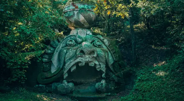 Ingresso del museo dei mostri: una bocca di pietra spalancata, incastonata nel verde di un bosco incantato.