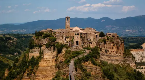 Civita di Bagnoregio, un borgo arroccato su speroni di tufo, domina i calanchi circostanti. Un ponte collega il paese alla terraferma.