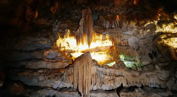 Interno di una grotta con stalattiti e stalagmiti illuminate, un paesaggio sotterraneo mozzafiato nelle grotte di Civita Castellana.
