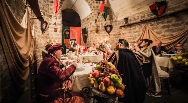 Banchetto medievale a Soriano nel Cimino, con figuranti in costume e un ricco centrotavola di frutta.