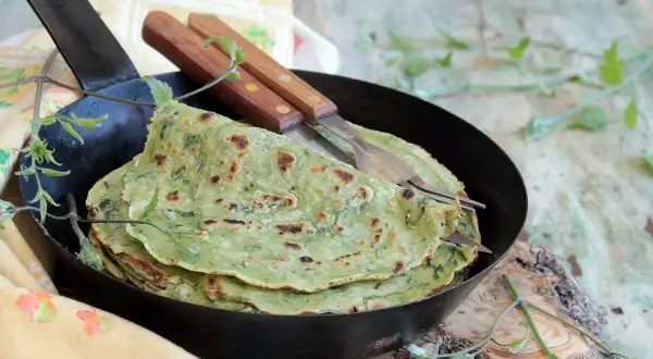 Fregnacce verdi, sottili e profumate, servite in padella con forchette. Un piatto che sa di tradizione e sapori genuini.