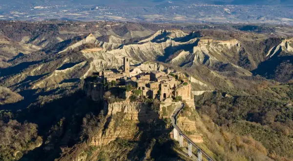 Civita di Bagnoregio, la città che muore, domina la valle dei calanchi. Un ponte pedonale collega il borgo arroccato su uno sperone di tufo.