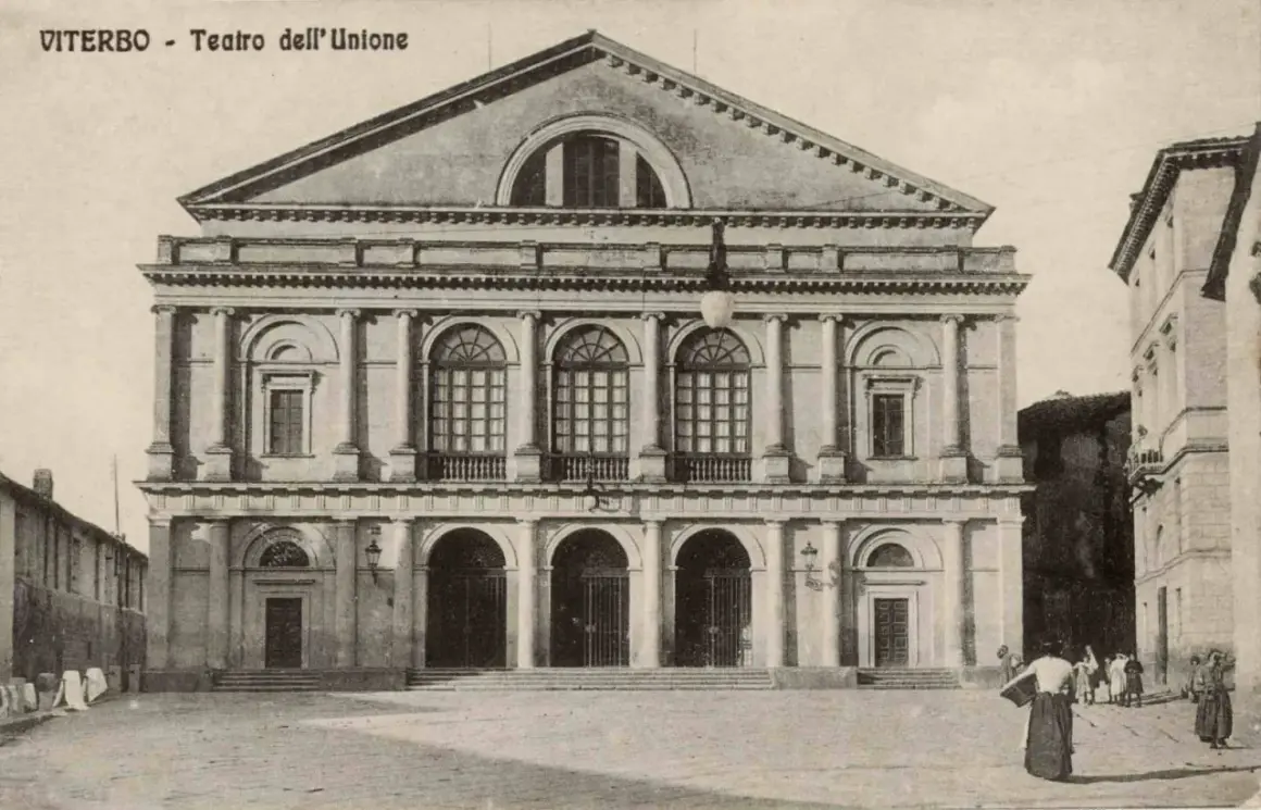 Il maestoso **Teatro dell'Unione** di Viterbo, con la sua facciata neoclassica e le arcate imponenti, si erge in una piazza storica.