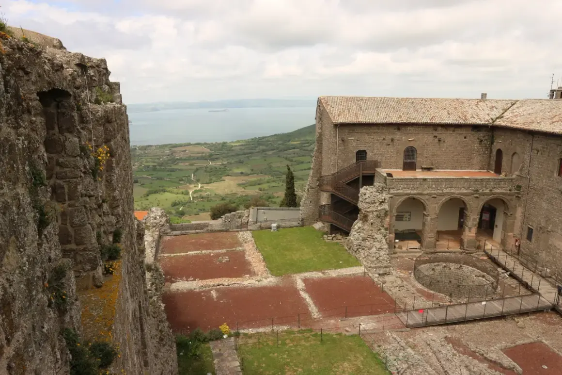Rocche antiche e un lago sullo sfondo, un paesaggio che evoca la storia della Tuscia, dove si trova questo luogo.