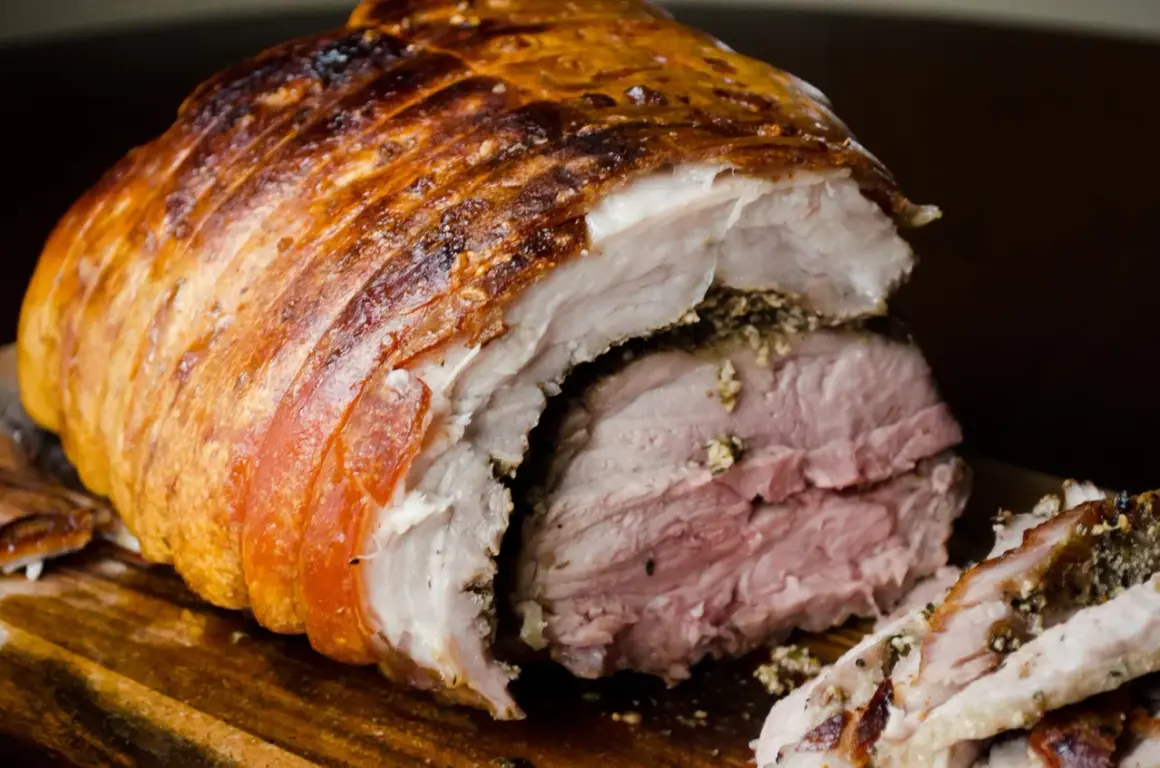 Porchetta viterbese succulenta, con crosta dorata e carne rosata, pronta per essere gustata.