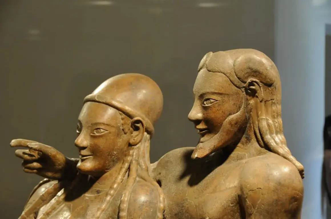 Coppia di statue in terracotta, parte di corredi funerari etruschi. Un uomo indica qualcosa, la donna lo guarda con un sorriso.
