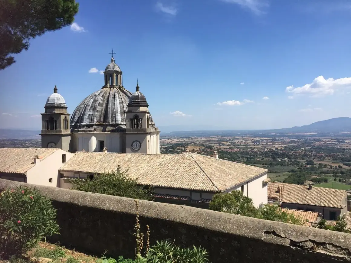 La Rocca dei Papi domina un paesaggio collinare sotto un cielo azzurro.