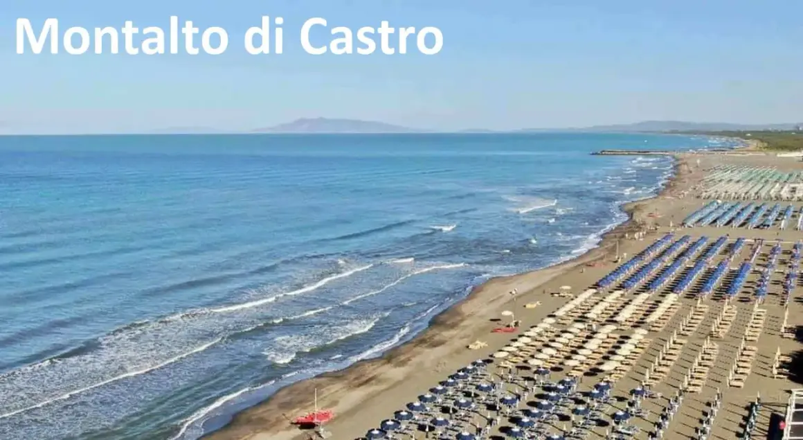 Spiaggia di Montalto di Castro con file ordinate di ombrelloni e lettini, mare azzurro e onde leggere.