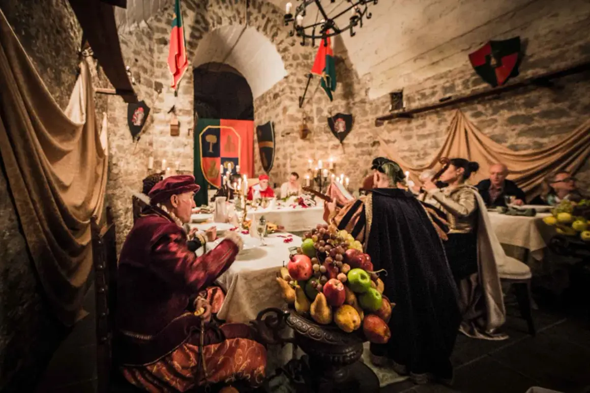 Banchetto medievale a Soriano nel Cimino, con figuranti in costume e un ricco centrotavola di frutta.
