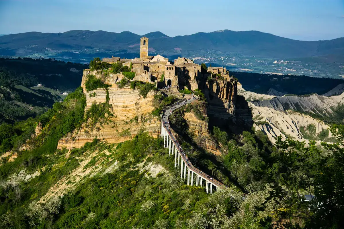 Civita di Bagnoregio, un borgo medievale arroccato su una rupe, collegato da un ponte pedonale. La provincia laziale offre panorami mozzafiato.