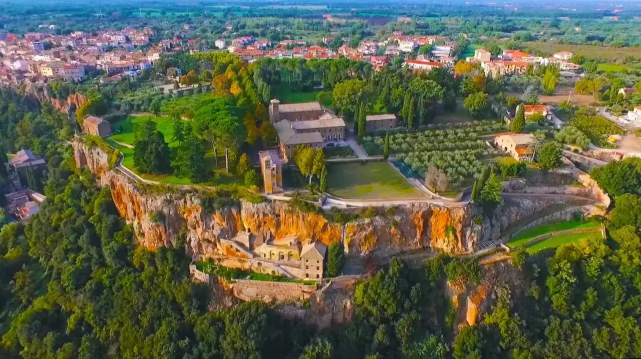 Panoramica di Castel Sant'Elia, cosa vedere: un borgo arroccato su una rupe, con edifici storici e uliveti.