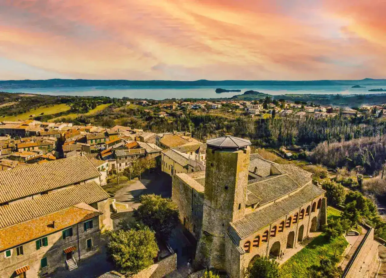 Borgo medievale con torre imponente e lago sullo sfondo. Scopri cosa vedere a Valentano, un gioiello tra storia e natura.