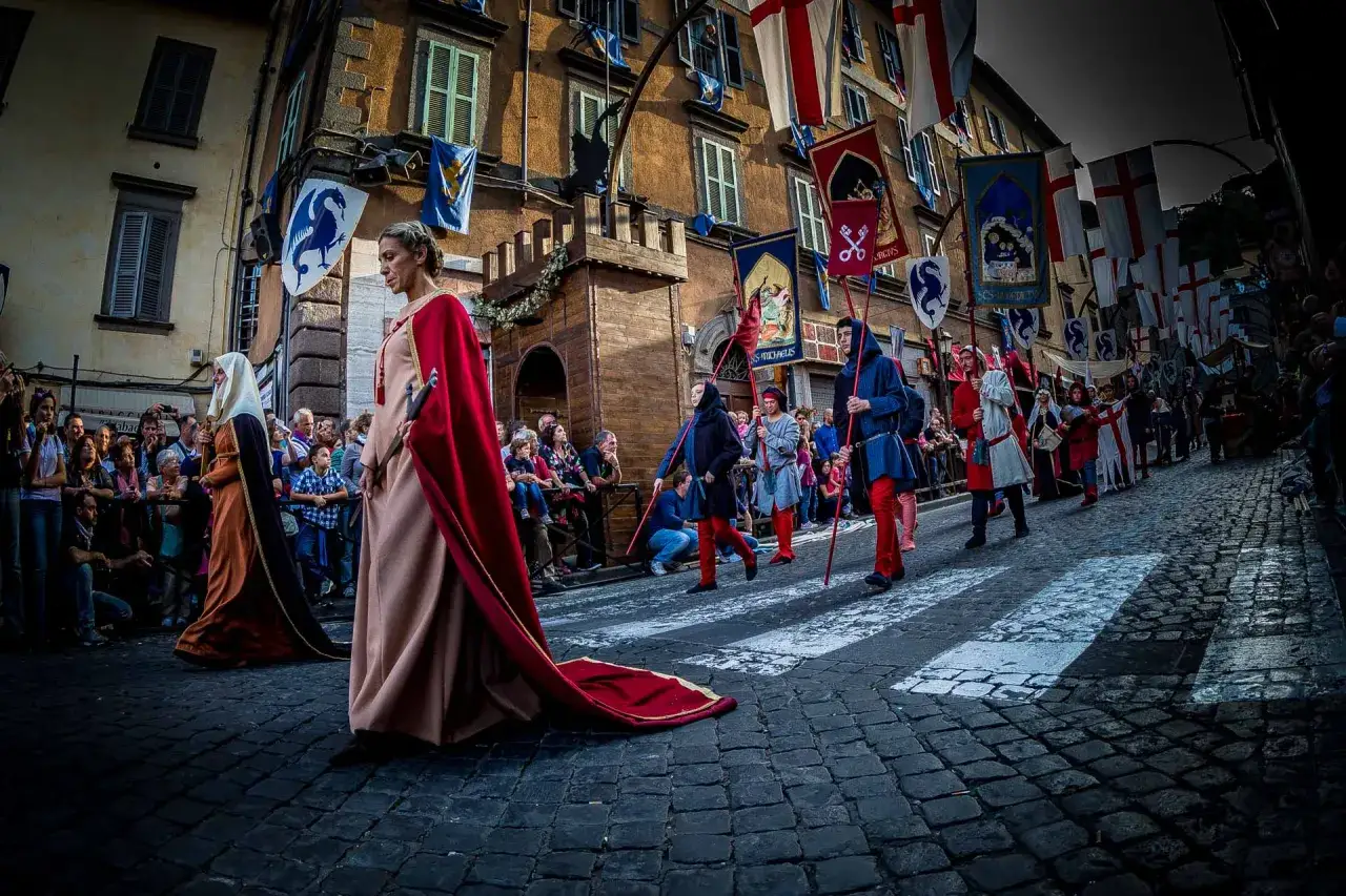 Parata storica a Soriano nel Cimino per la sagra. Donne in abiti d'epoca e figuranti in costume medievale sfilano tra le bandiere.