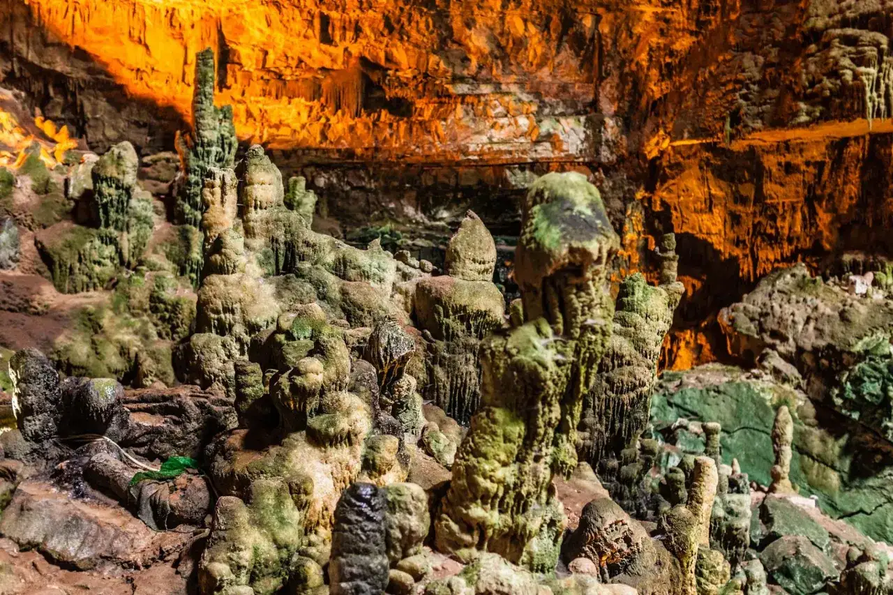 Formazioni rocciose e stalattiti nelle suggestive grotte di Civita Castellana, illuminate da una luce calda e dorata.