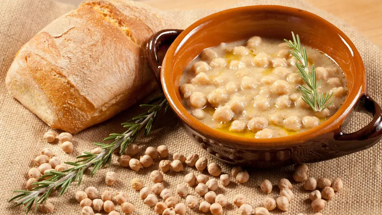 Zuppa ceci e castagne viterbese in ciotola di terracotta, con pane rustico e rosmarino.