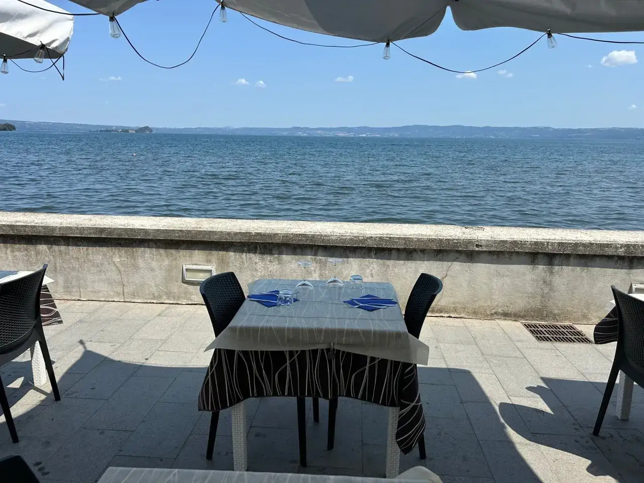 Tavolo apparecchiato con vista sul lago, ideale per gustare i Bolsena ristoranti.