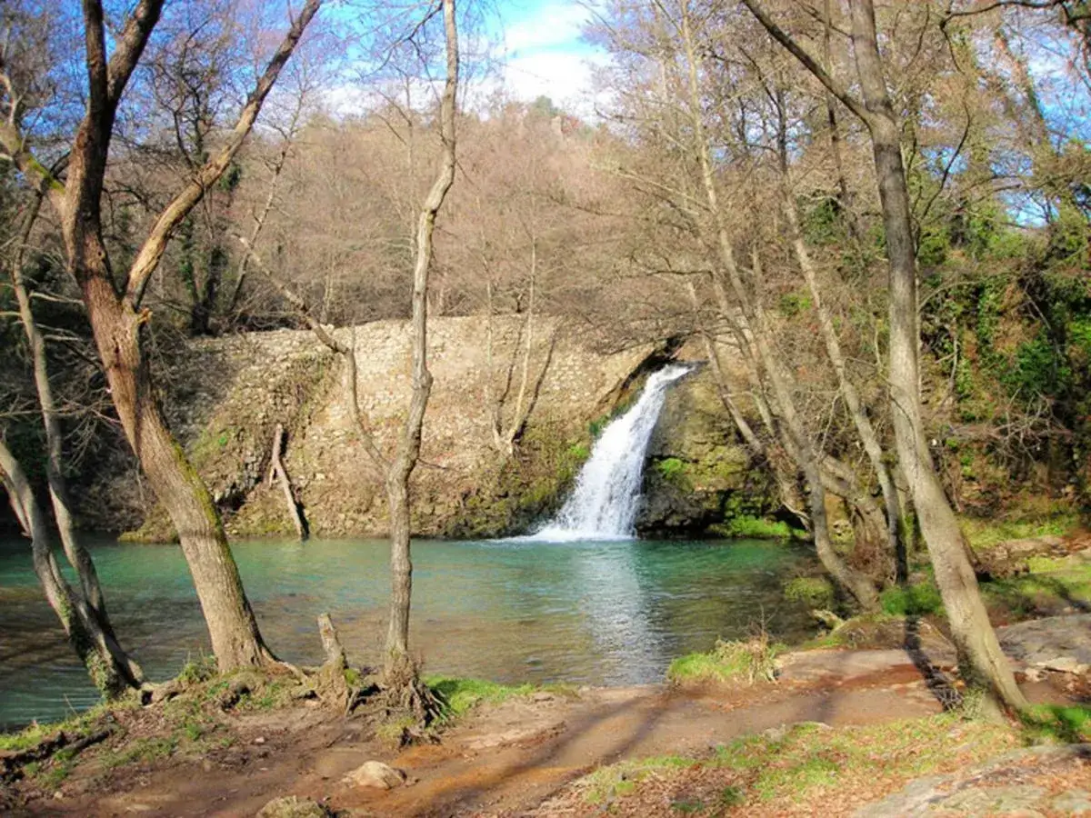 Cascate della Mola: un'oasi di pace con acqua cristallina e alberi spogli che incorniciano la cascata.